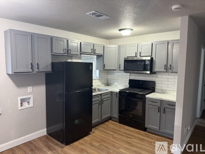 A room with a ceiling fan and two windows.