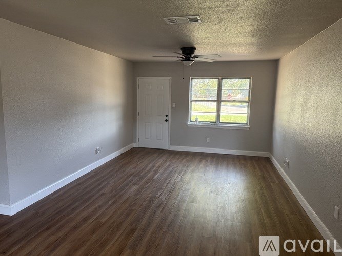 A room with wooden flooring and a ceiling fan.