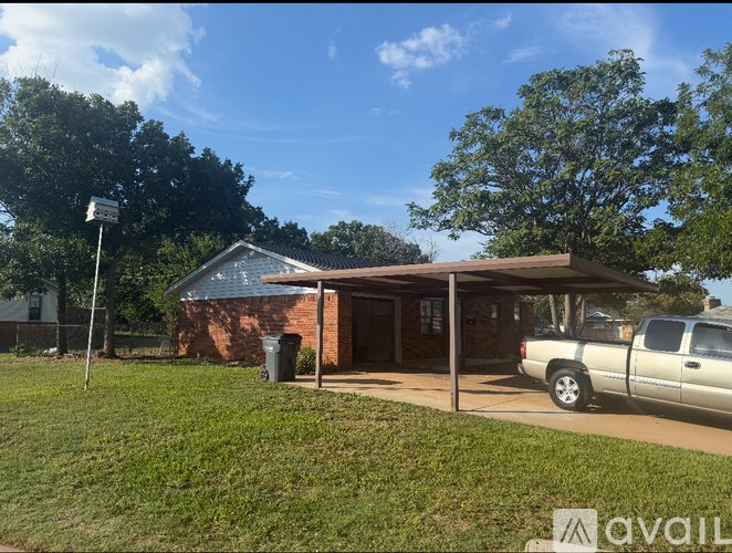 A house with a brown roof and a white pickup truck parked in front.