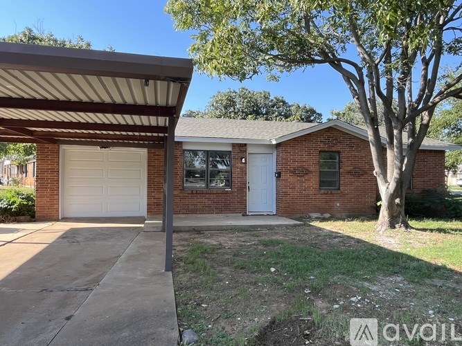 A house with a white garage door and a tree in front.
