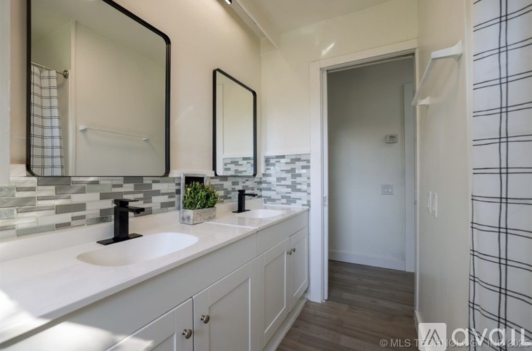 A bathroom with two sinks and a mirror above the counter.