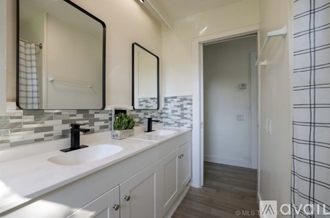 A bathroom with two sinks and a mirror above the counter.