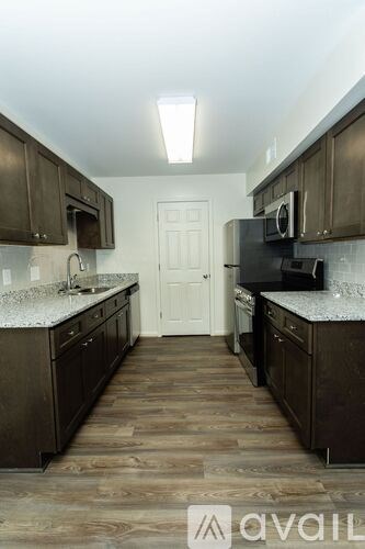A kitchen with dark wood cabinets and a white door in the middle.