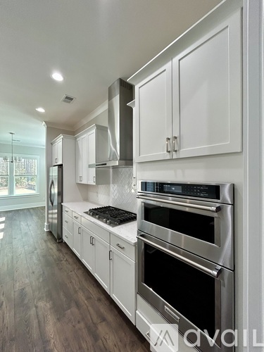 A modern kitchen with stainless steel appliances and white cabinets.