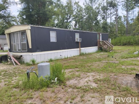 A black and white trailer is parked in a grassy area.