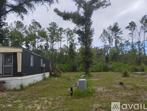 A house surrounded by trees and grass.