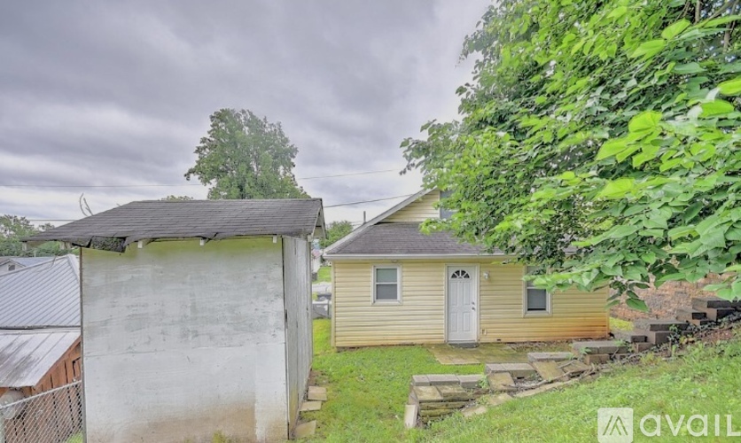 A house with a shed and a fence in front of it.