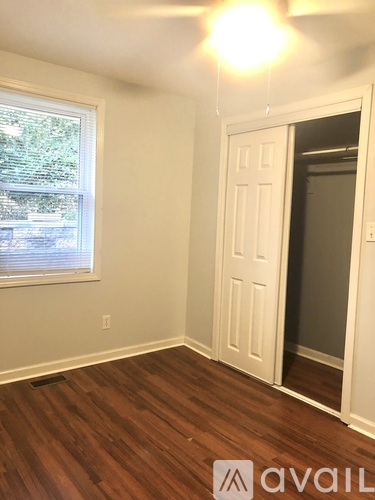 A room with a wooden floor and a white door.