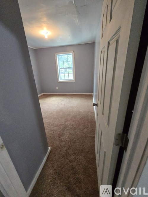 A room with a carpeted floor and a window.