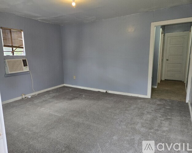 A room with a window and a door is available for rent.