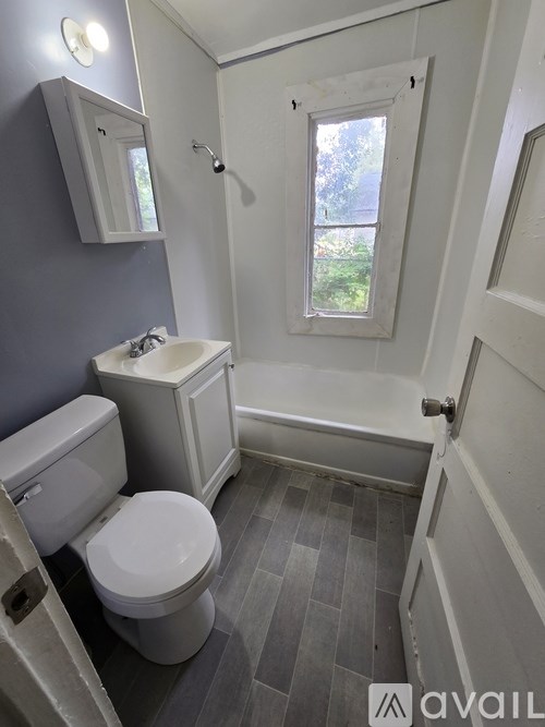 A bathroom with a toilet, sink, and tub.