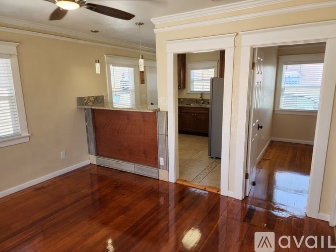 A room with a wooden floor and a ceiling fan.