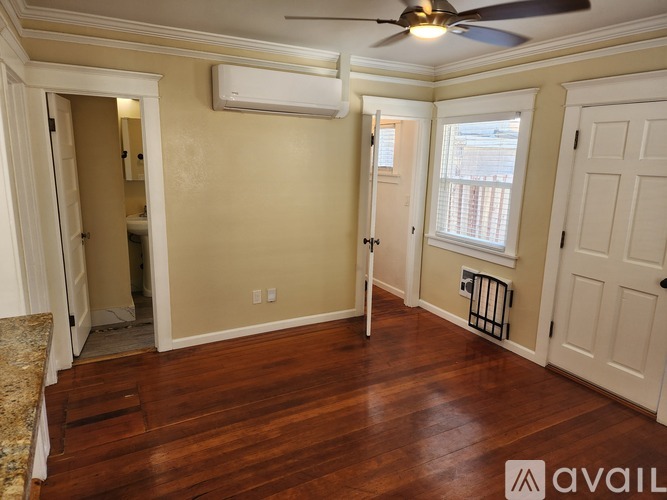 A room with a ceiling fan and a window with blinds.