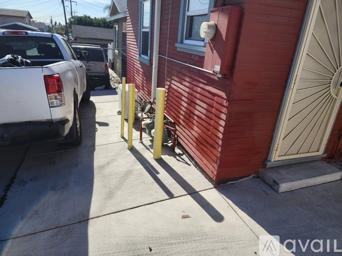 A red building with a white truck parked in front of it.