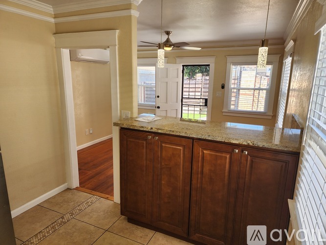 A kitchen with wooden cabinets and a marble countertop.