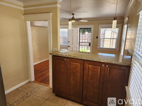 A kitchen with wooden cabinets and a marble countertop.