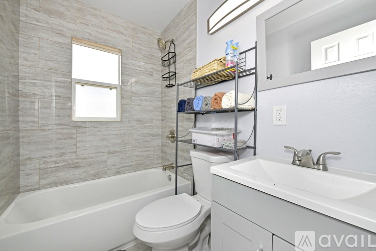A bathroom with a white tub, toilet, and sink.