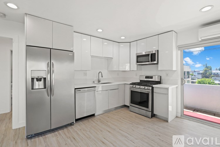 A modern kitchen with stainless steel appliances and white cabinets.