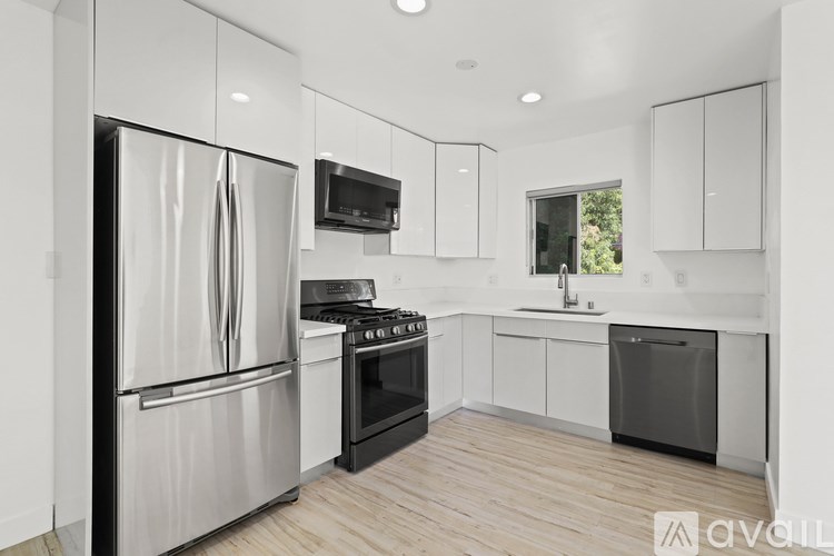 A modern kitchen with stainless steel appliances and white cabinetry.