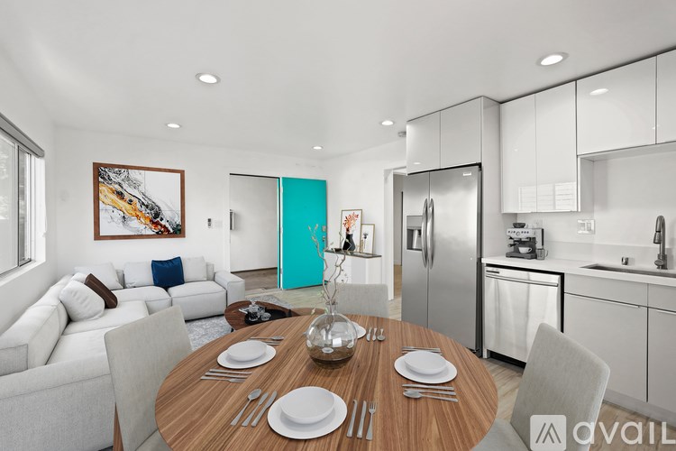 A modern kitchen with a dining table set for two.