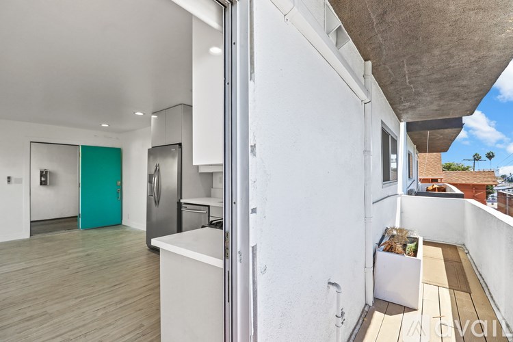 A modern kitchen with a balcony overlooking the city.