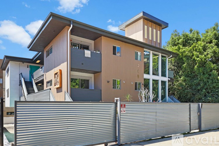 A modern house with a grey fence in front.