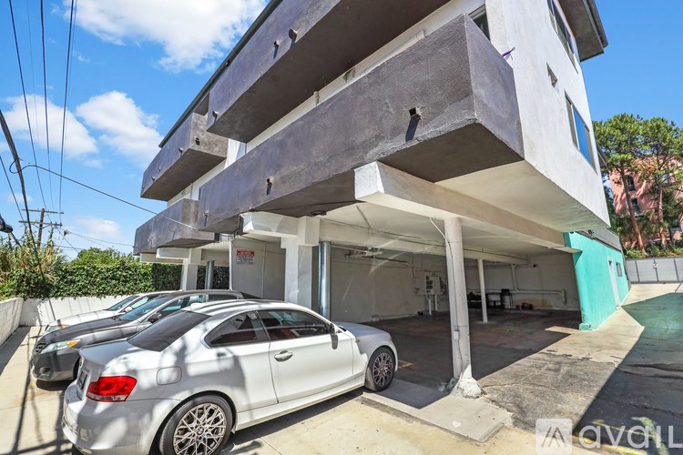 A white car is parked in front of a modern two-story house.