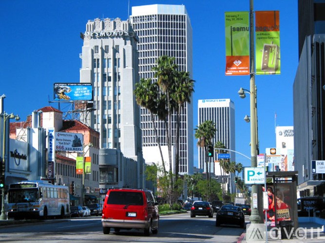 A red van is driving down a busy street.