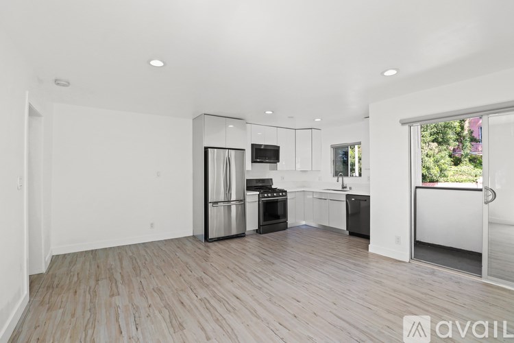 A spacious kitchen with white cabinets and stainless steel appliances.