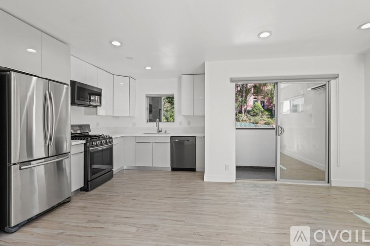 A modern kitchen with stainless steel appliances and white cabinets.
