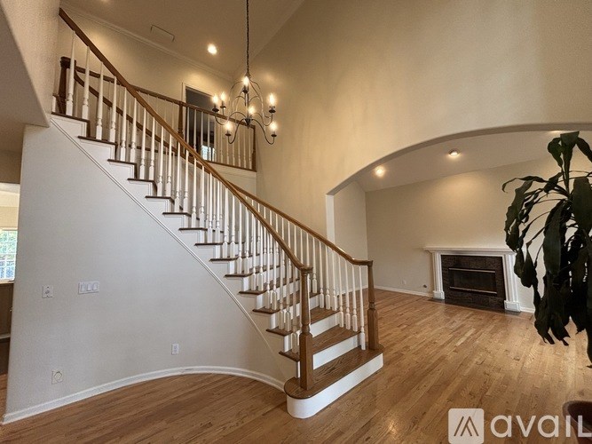 A living room with a staircase and a fireplace.