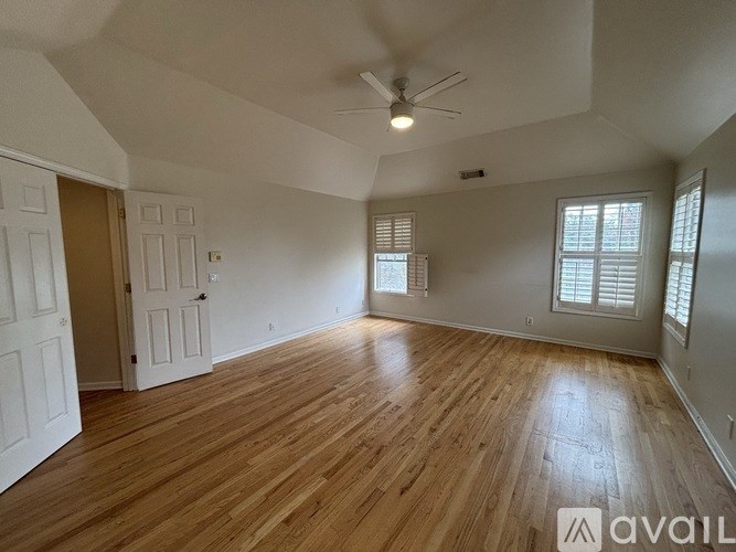 A room with wooden flooring and a ceiling fan.