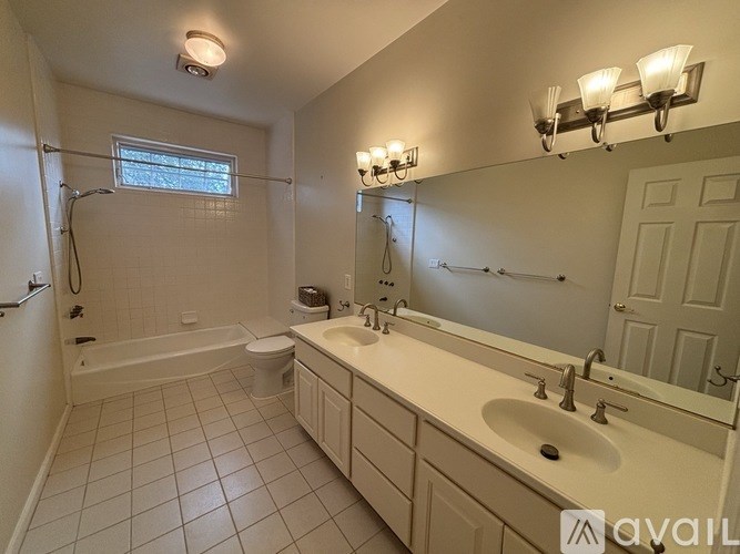 A bathroom with a white sink, a white toilet, a white bathtub, and a white door.