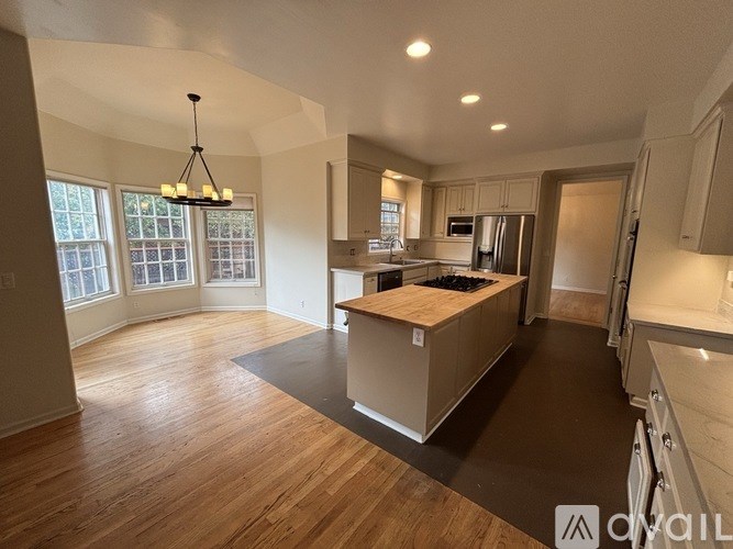 A modern kitchen with wooden floors and a large island.