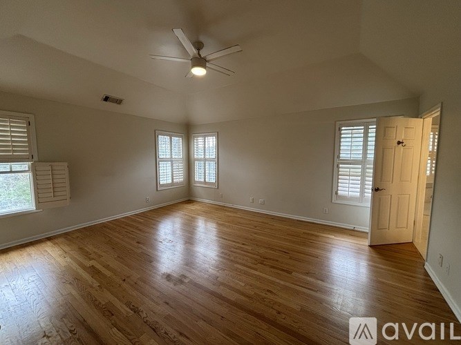 A room with wooden flooring and a ceiling fan.