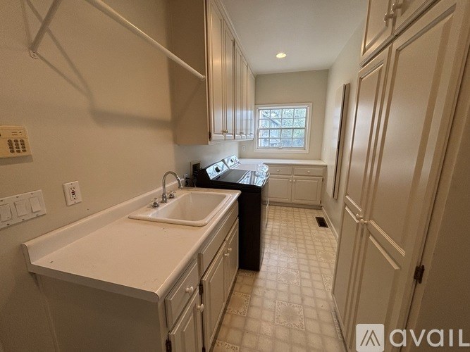 A kitchen with white cabinets and a white sink.