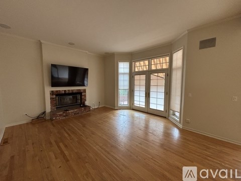 A living room with a fireplace and a television mounted on the wall.