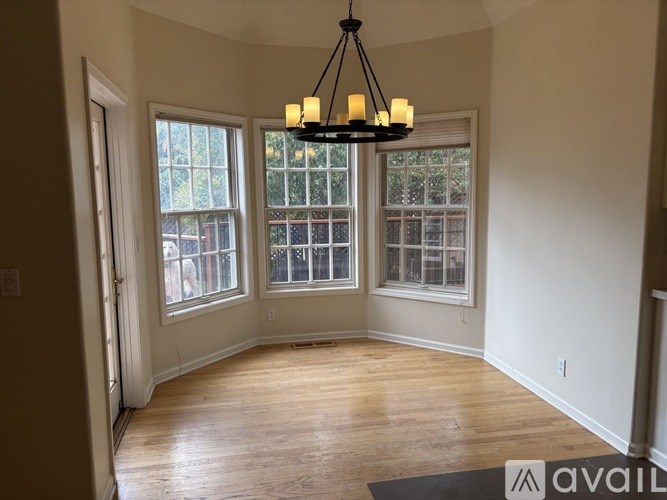 A room with a chandelier and large windows.