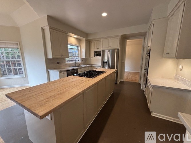 A kitchen with a wooden countertop and stainless steel appliances.