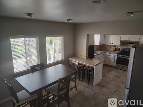 A kitchen with a table and chairs in front of a window.