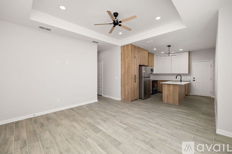 A spacious kitchen with a ceiling fan and lighting fixtures.