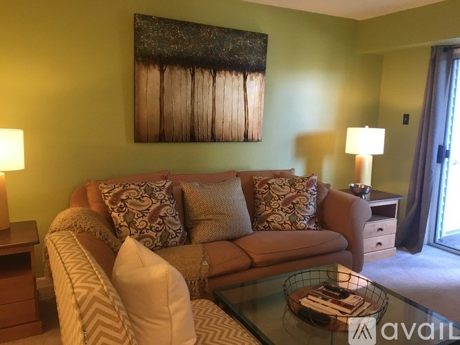 A living room with a couch, a coffee table, and a painting on the wall.