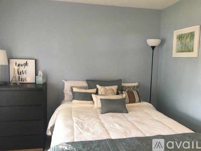 A bedroom with a bed, nightstand, and lamp.