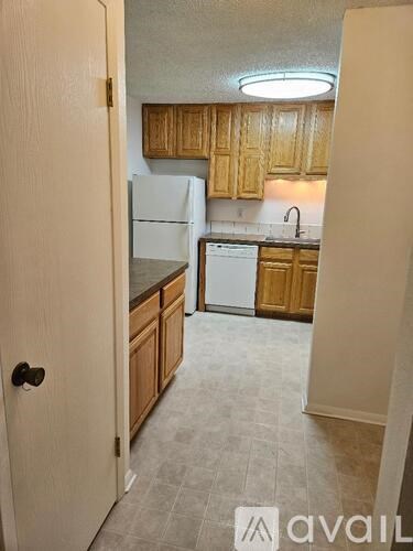 A kitchen with wooden cabinets and a white refrigerator.