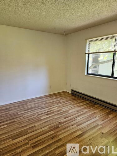 A room with wooden flooring and a window.