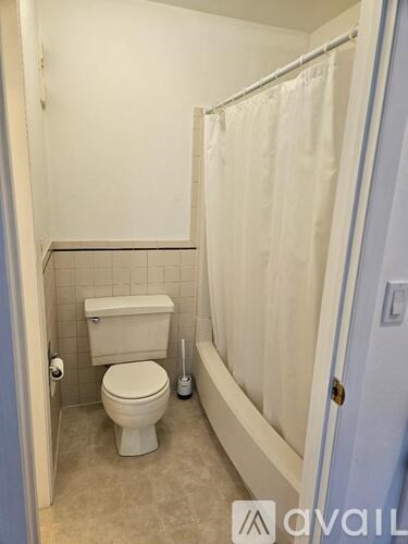 A small bathroom with a toilet and a shower.