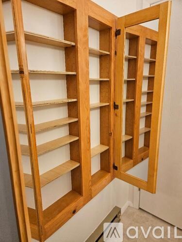 A wooden shelving unit with multiple shelves is open.