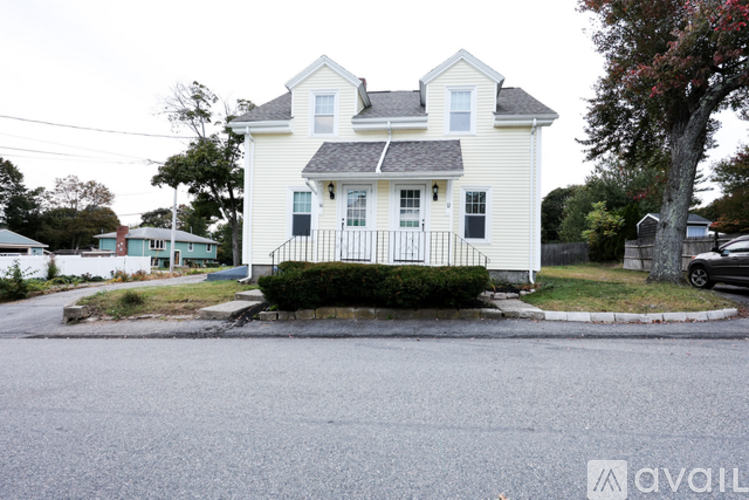 A white house with a black fence in front of it.