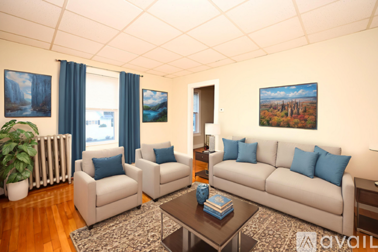 A living room with a white couch, two chairs, and a coffee table.