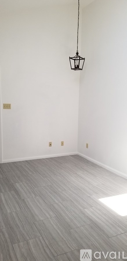 A room with a grey floor and a hanging lamp.